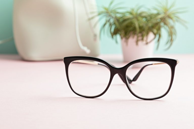 Stylish eyeglasses over pastel background. Optical store, eye test, vision examination at optician